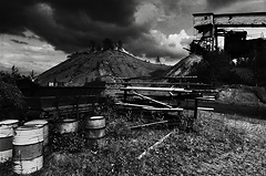 Stripa cinder heap with cloud formations and oil barrels